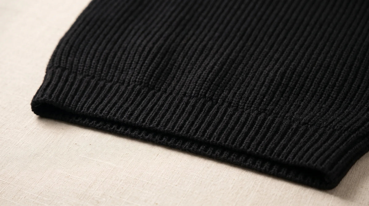 Close-up of the Como Black Half-Zip Knit's ribbed hem and chunky rib knit