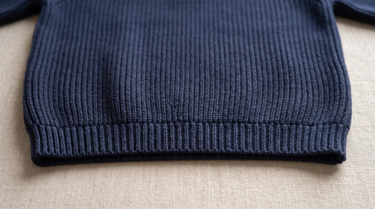 Close-up of the Como Navy Half-Zip Knit's ribbed hem and chunky rib knit