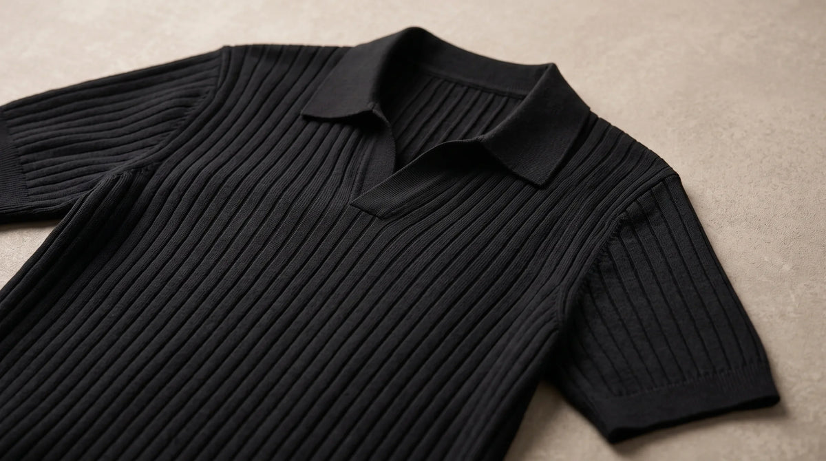 Close-up of the Cove Black Polo's open buttonless collar and fine rib knit