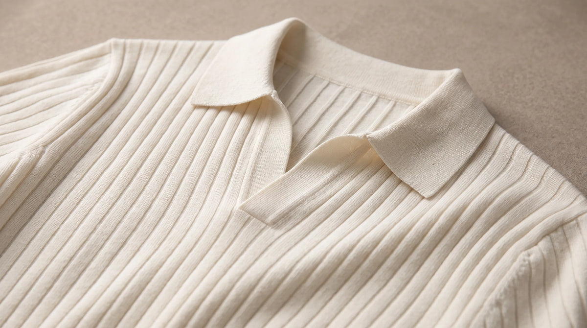 Close-up of the Cove Short Sleeve Polo's open buttonless collar and fine rib knit