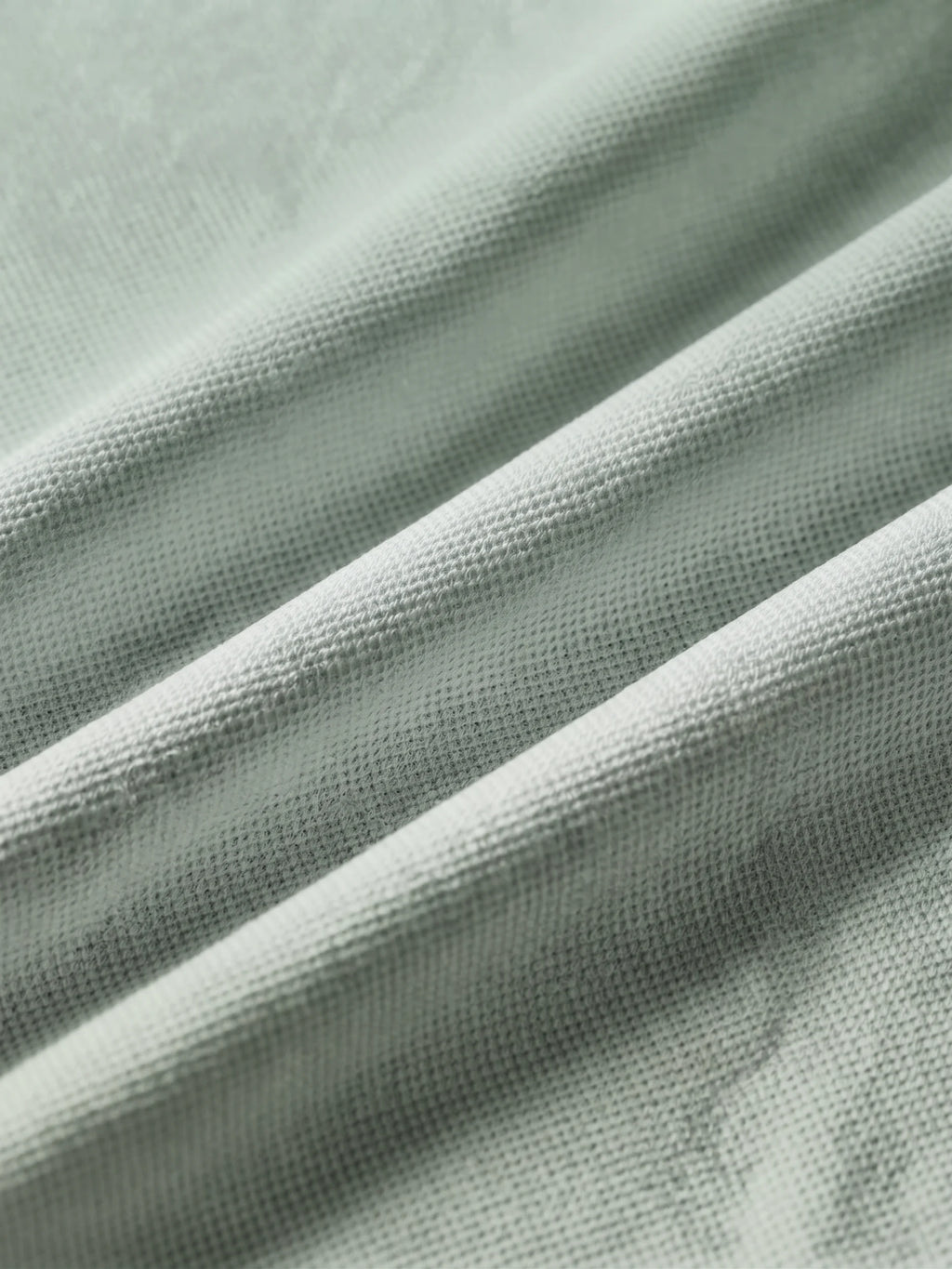 Close detail of the sage green bamboo-fibre piqué