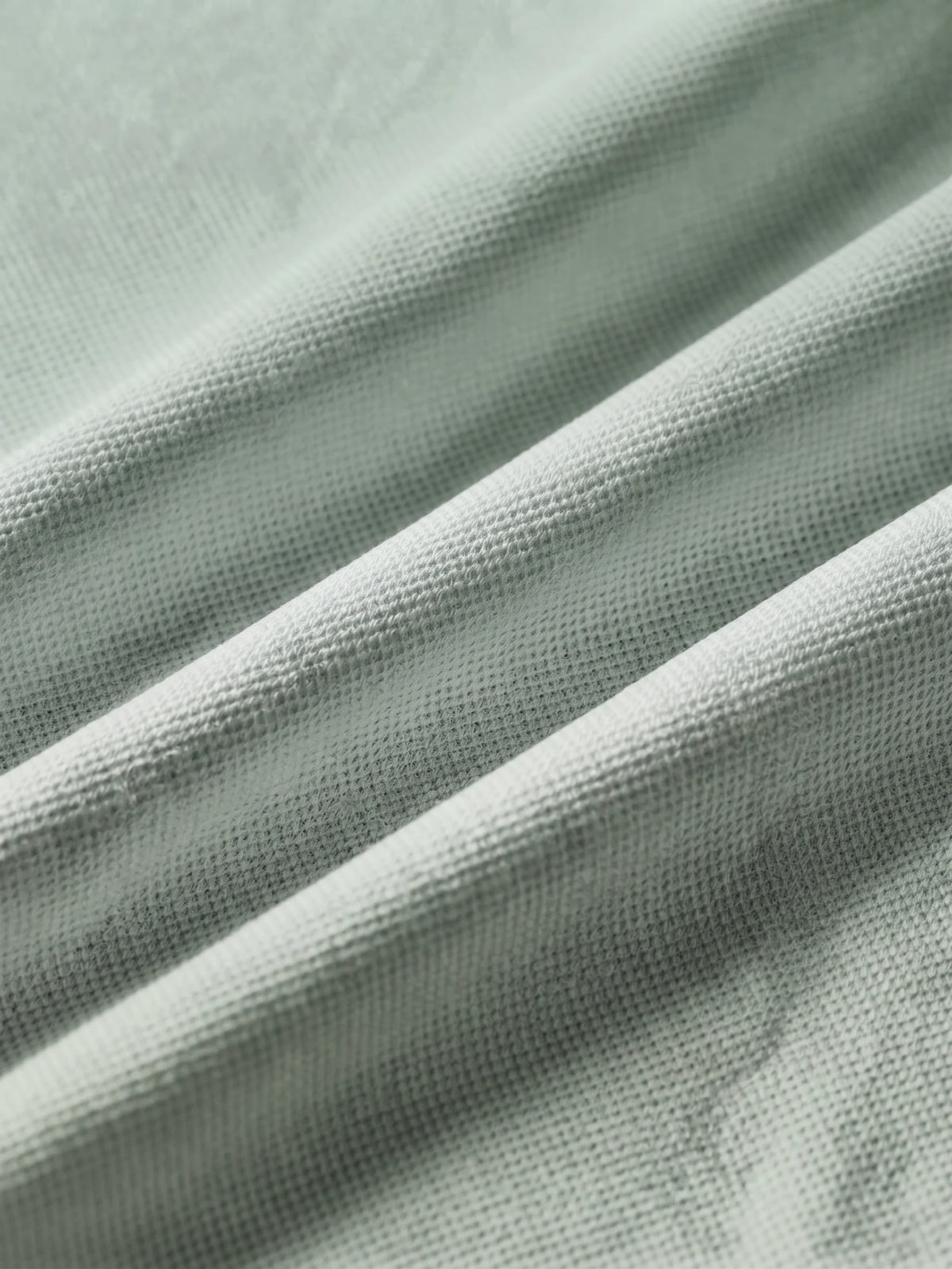 Close detail of the sage green bamboo-fibre piqué