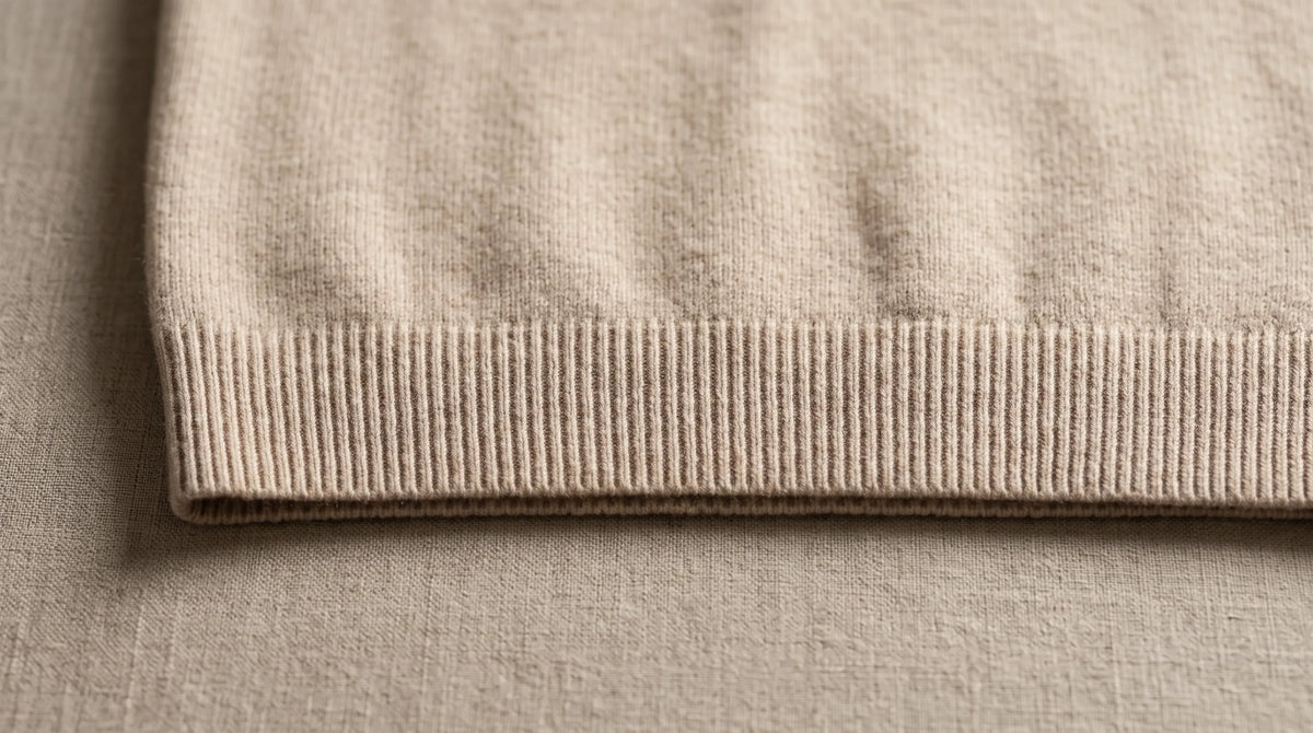 Close-up of the Riva Beige Roll-Neck's ribbed hem and fine knit