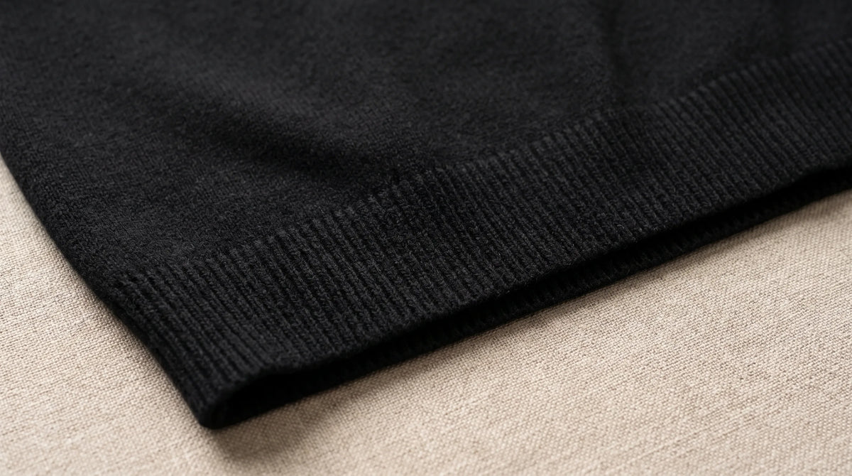 Close-up of the Riva Black Roll-Neck's ribbed hem and fine knit