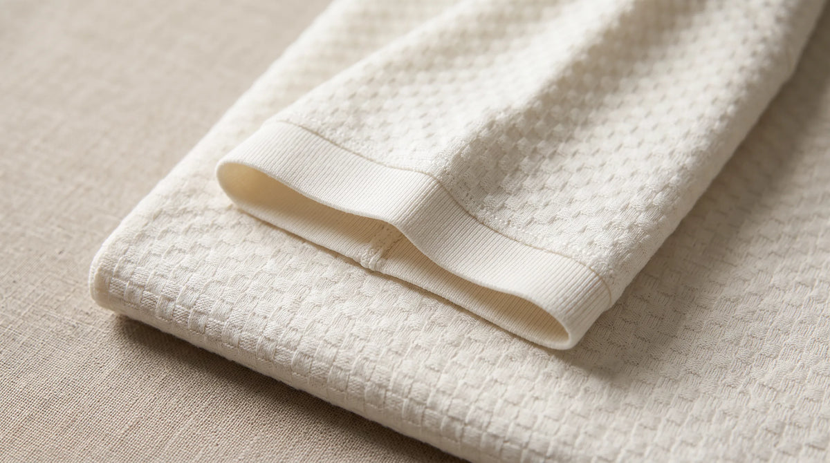 Close-up of the Saint-Tropez Port Polo's sleeve and textured box-check knit
