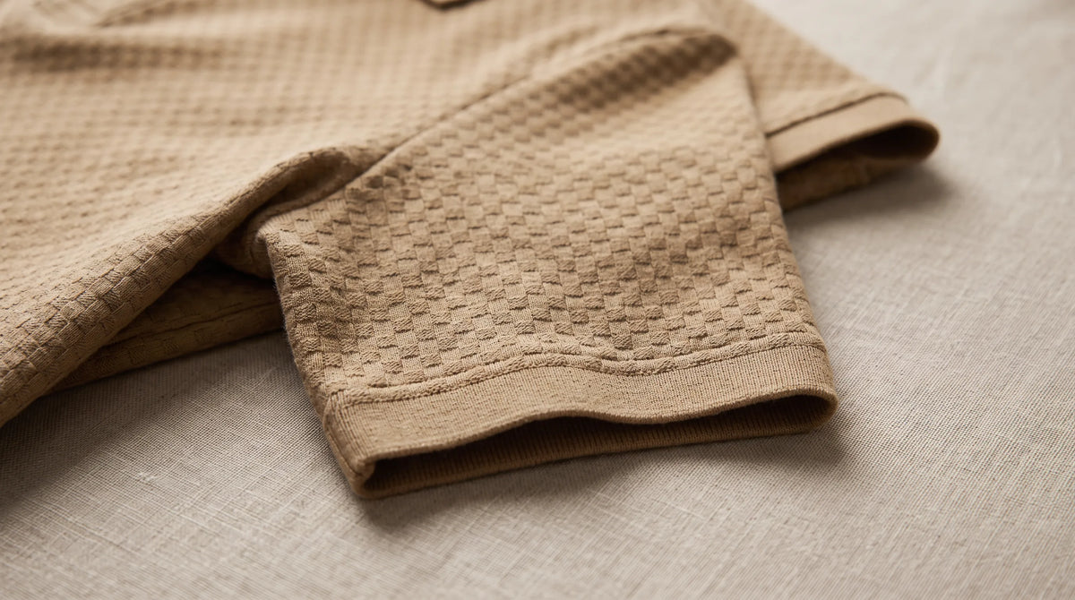 Close-up of the Saint-Tropez Textured Polo's sleeve and textured box-check knit